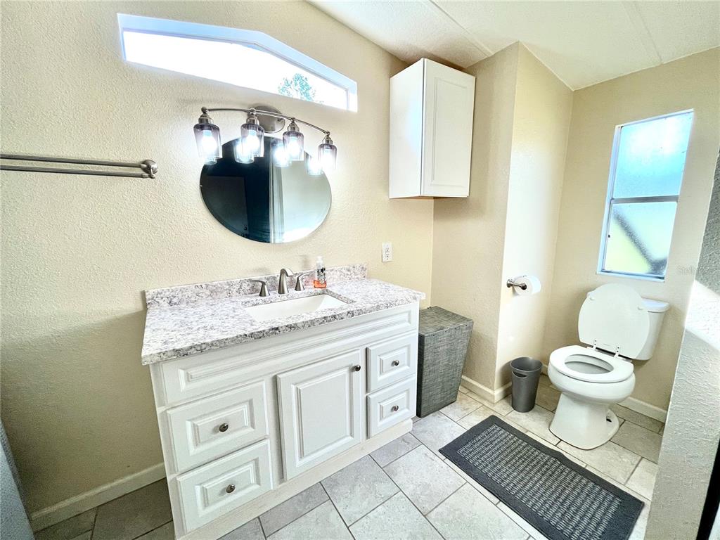 4008 77th Boulevard Jasper, FL 32052 - Photo 10 of 35 a bathroom with a granite countertop toilet sink and mirror