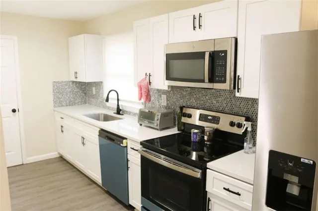 a kitchen with stainless steel appliances granite countertop a sink stove and microwave