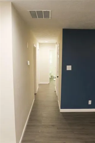 a view of a hallway with wooden floor