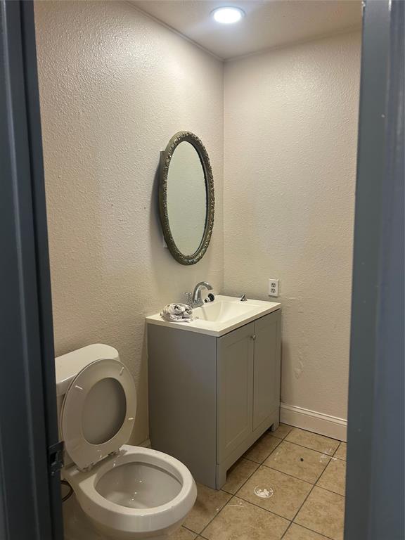 2043 Chestnut Road Carrollton, TX 75007 - Photo 12 of 19 a bathroom with a granite countertop toilet sink and mirror