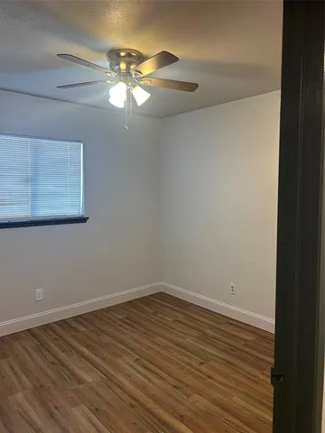a view of a room with wooden floor and fan
