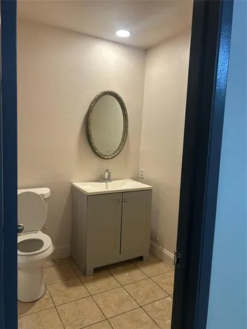 a bathroom with a toilet mirror vanity and a sink
