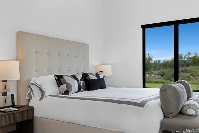 a bedroom with a bed and a large window