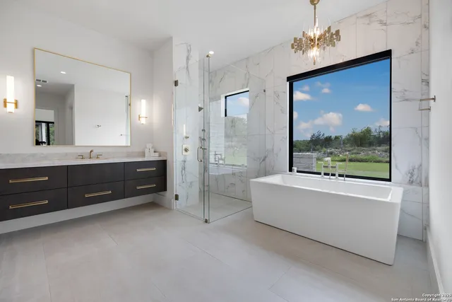 a spacious bathroom with a tub sink shower and mirror