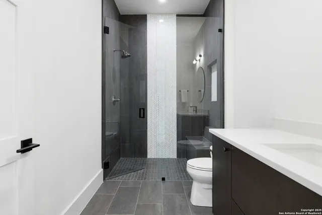 a bathroom with a sink a toilet and shower