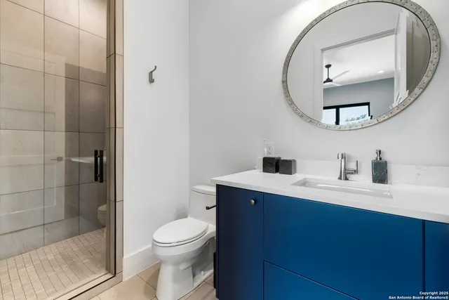 a bathroom with a toilet a sink a mirror and shower