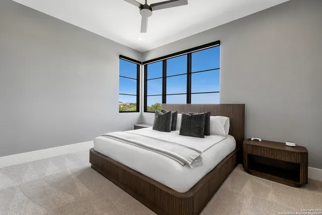 a bedroom with a bed and a ceiling fan