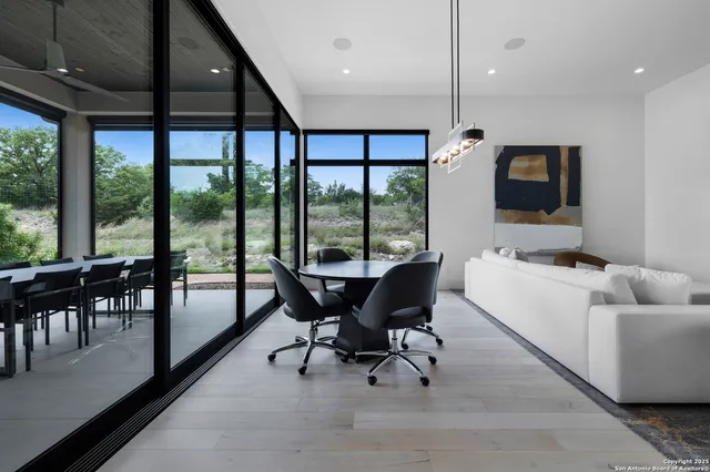 a living room with furniture and floor to ceiling windows