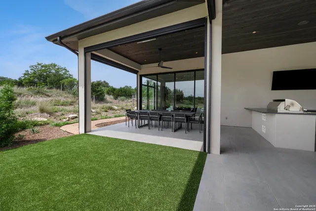 a view of a patio with table and chairs potted plants with floor to ceiling window