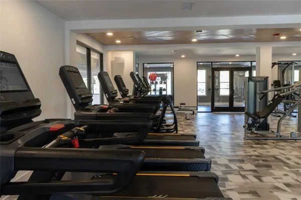 a living room with furniture a wooden floor and gym equipment
