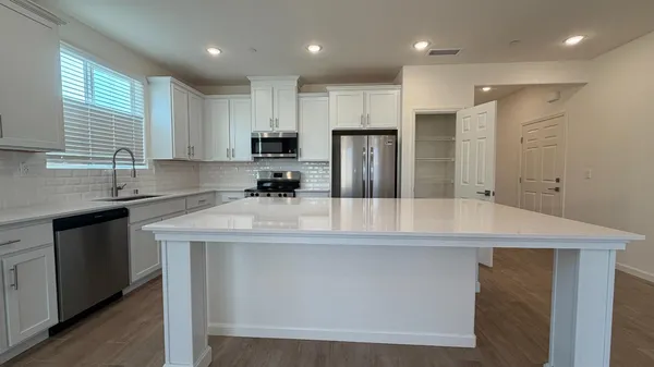 a kitchen with stainless steel appliances granite countertop a sink a stove and a microwave