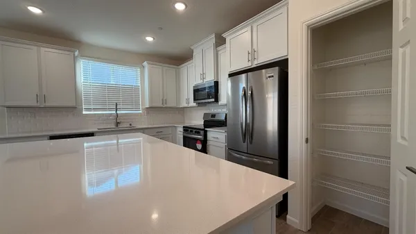 a kitchen with stainless steel appliances a stove a microwave and a refrigerator