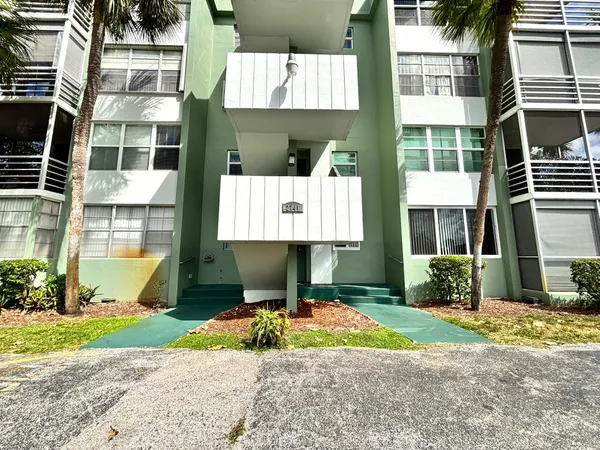 a front view of a building with a garden