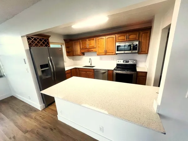 a kitchen with stainless steel appliances a refrigerator stove and wooden floor