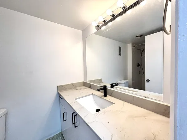 a room with a mirror and a glass door shower