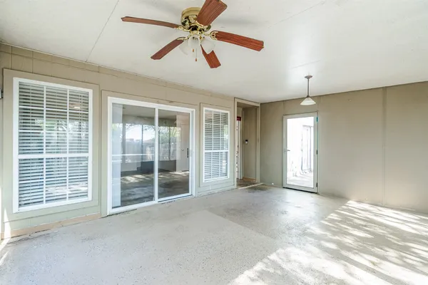 a view of empty room with window and ceiling fan