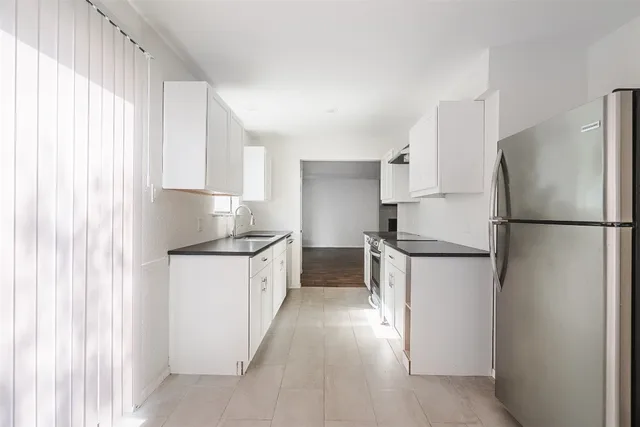 a kitchen with a refrigerator sink and cabinets