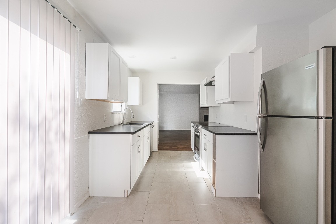2106 Lamplight Village Circle, Unit A Austin, TX 78727 - Photo 7 of 19 a kitchen with a refrigerator sink and cabinets