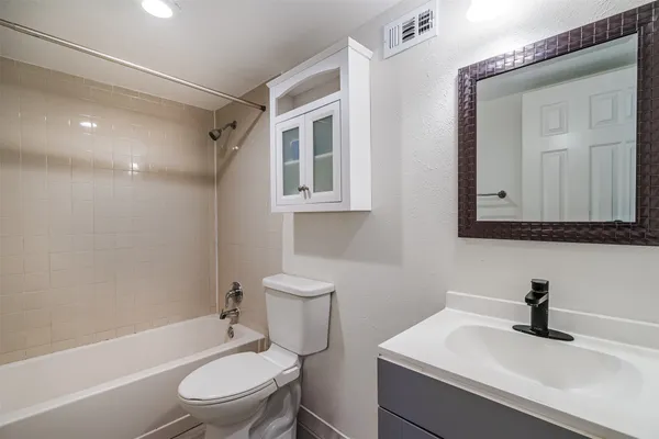 a white toilet sitting next to a bathroom sink