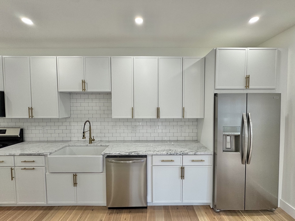 20 Broad Street, Unit 4 Medway, MA 02053 - Photo 4 of 10 a kitchen with white cabinets and stainless steel appliances