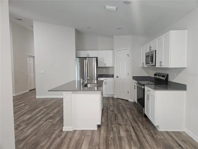 a kitchen with a sink cabinets stainless steel appliances and a window