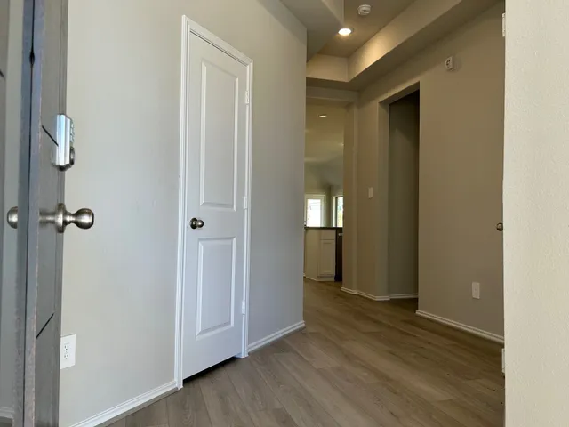 a kitchen with stainless steel appliances a sink a stove a microwave a refrigerator a cabinets and wooden floor