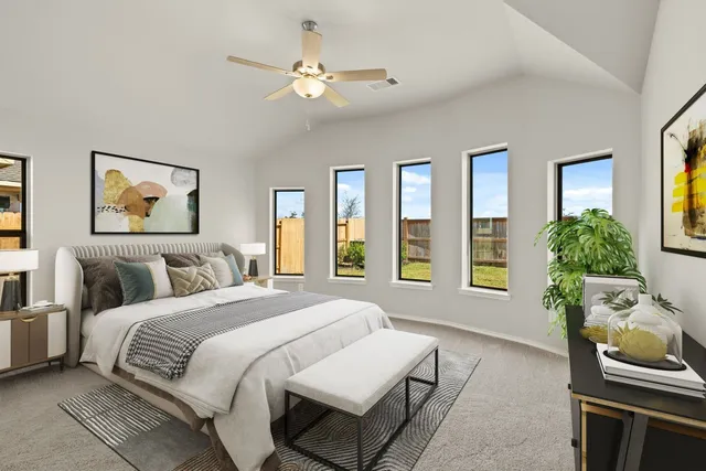 a spacious bedroom with a bed a couch and a window