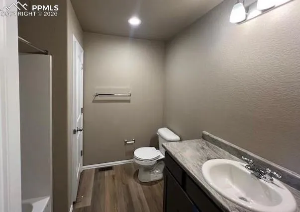 a bathroom with a granite countertop toilet a sink and a mirror