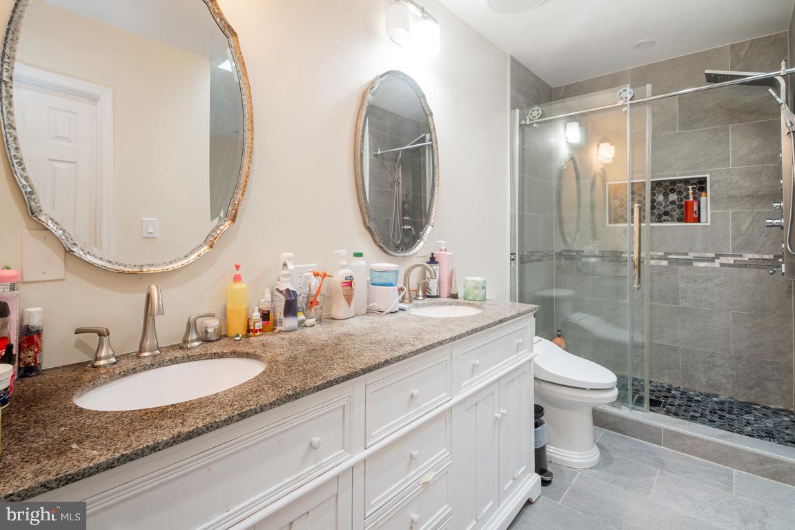 1710 Bargers Road Gambrills, MD 21054 - Photo 20 of 22 a bathroom with a granite countertop toilet a sink and a mirror
