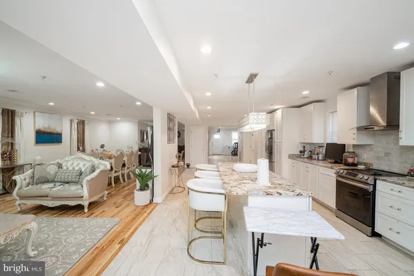 a large kitchen with kitchen island a large counter space a sink stainless steel appliances and cabinets