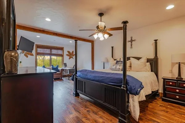 a bedroom with a bed a chandelier and flat screen tv