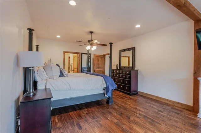 a spacious bedroom with a large bed a chandelier and dresser