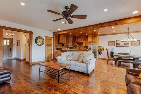 a living room with furniture kitchen view and a large window