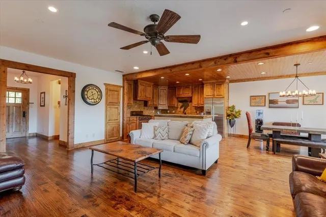 a living room with furniture kitchen view and a large window