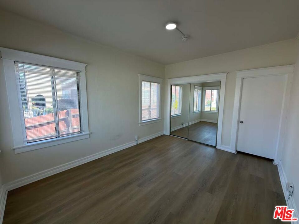 1298 Queen Anne Place, Unit 1 Los Angeles, CA 90019 - Photo 2 of 10 a view of an empty room with wooden floor and a window
