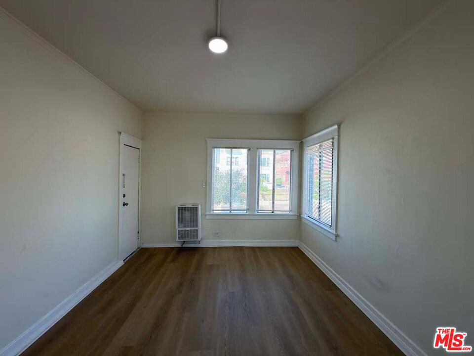 1298 Queen Anne Place, Unit 1 Los Angeles, CA 90019 - Photo 5 of 10 an empty room with wooden floor and windows