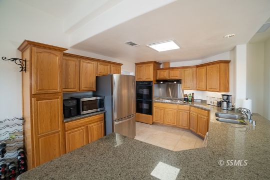 411 North Nolan Street Ridgecrest, CA 93555 - Photo 3 of 43 a kitchen with stainless steel appliances a refrigerator sink and stove