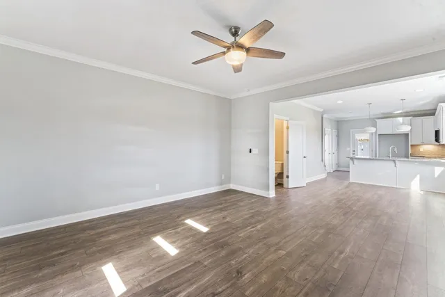 a view of a livingroom with a ceiling fan & wooden floor