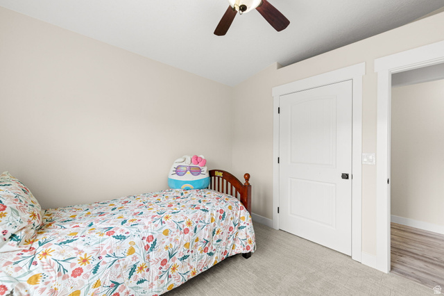 2591 East Washington Dam Road Washington, UT 84780 - Photo 42 of 67 Carpeted room featuring a white two-panel door with black hardware, a ceiling fan with wood-finish blades, and neutral wall paint