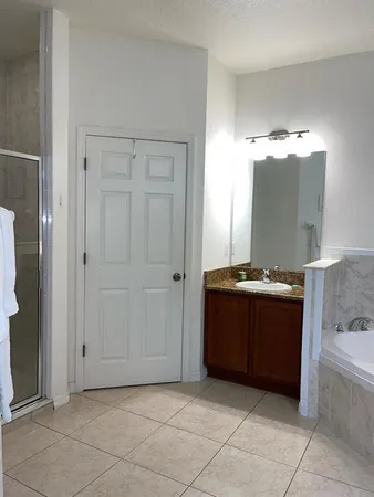 a bathroom with a potted plant on the wall and a shower