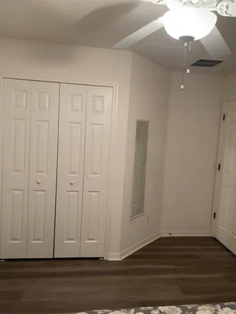 a view of a livingroom with wooden floor and a ceiling fan