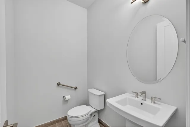 a bathroom with a sink a toilet and mirror