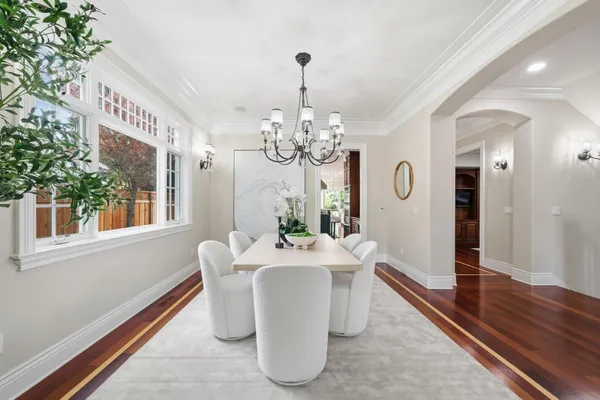 a open kitchen with stainless steel appliances kitchen island granite countertop a refrigerator a stove top oven and a dining table with wooden floor