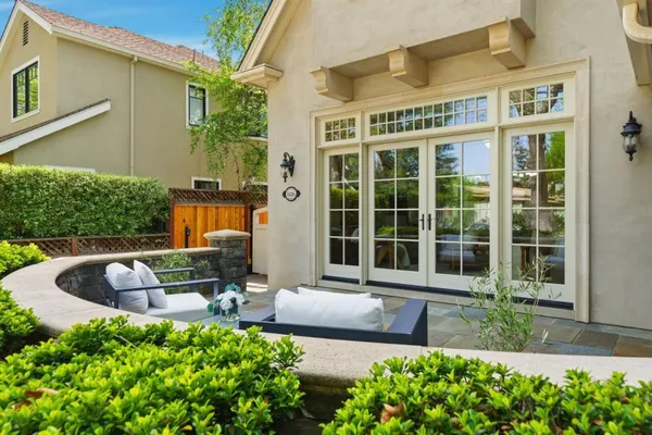a view of a patio with couches table and chairs potted plants and large tree