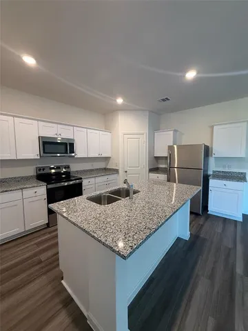 a view of kitchen with kitchen island sink and wooden floor