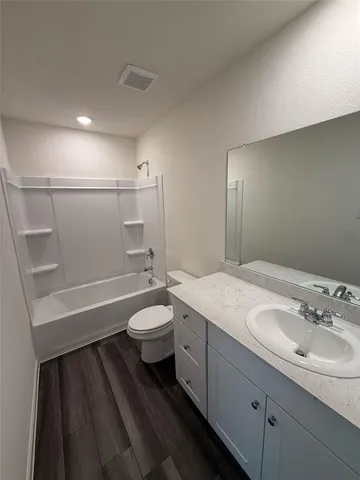 a bathroom with a sink a toilet a tub and shower