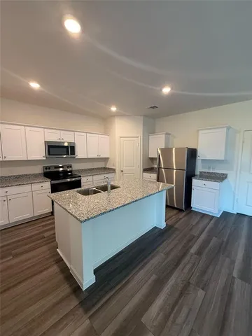 a large kitchen with stainless steel appliances granite countertop a stove and a refrigerator