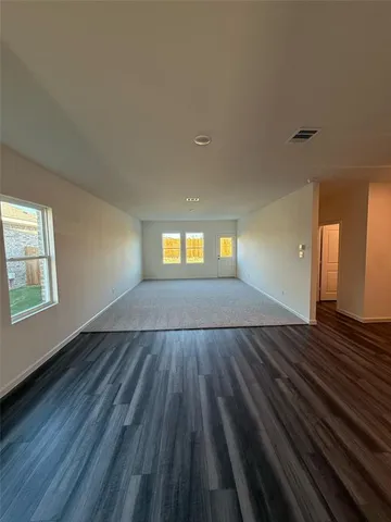 a view of empty room with window and wooden floor