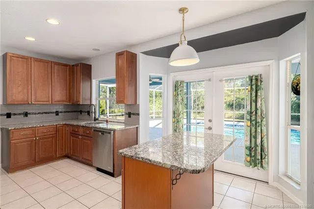 a kitchen with stainless steel appliances granite countertop stove top oven and cabinets