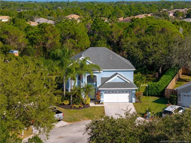 an aerial view of a house with yard and green space